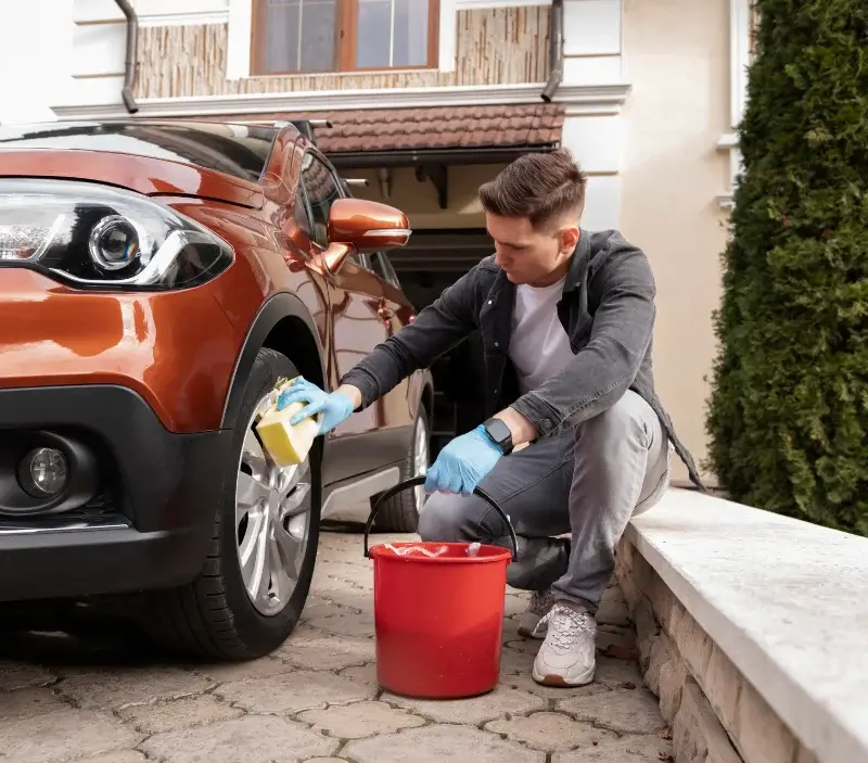 Lavage auto à domicile Ponlat-Taillebourg : professionnel intervenant sur un véhicule